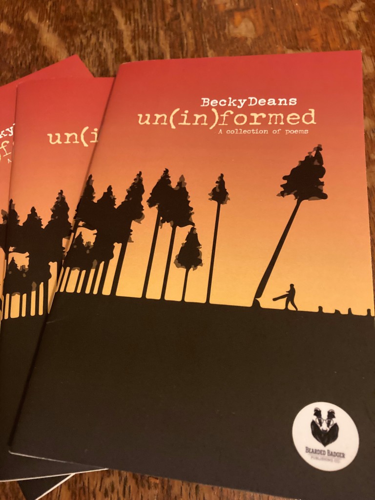 Copies of un(in)formed, published by Bearded Badger Press in April 2021.